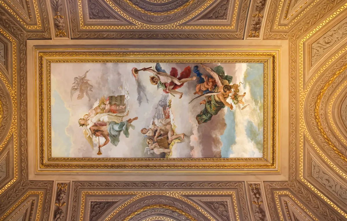 Stunning frescoed ceiling depicting classical Roman art within ornate architectural framing.