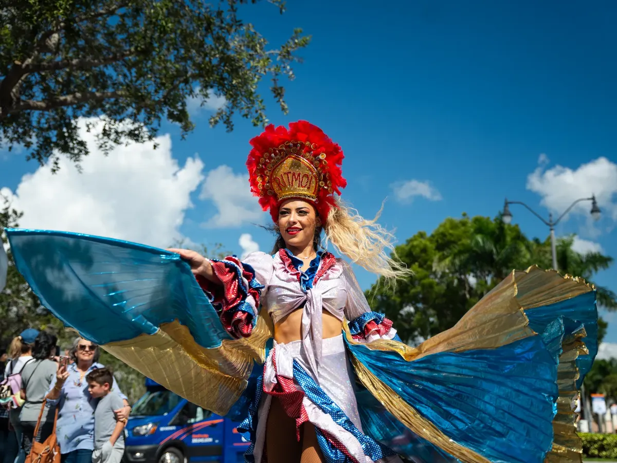 Vibrant dancer in traditional costume performing at Miami street festival parade.
