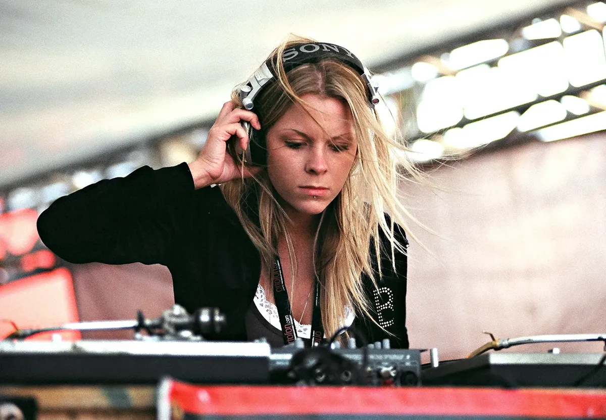 A DJ focusing on mixing music at an outdoor concert in Miami Beach, Florida.