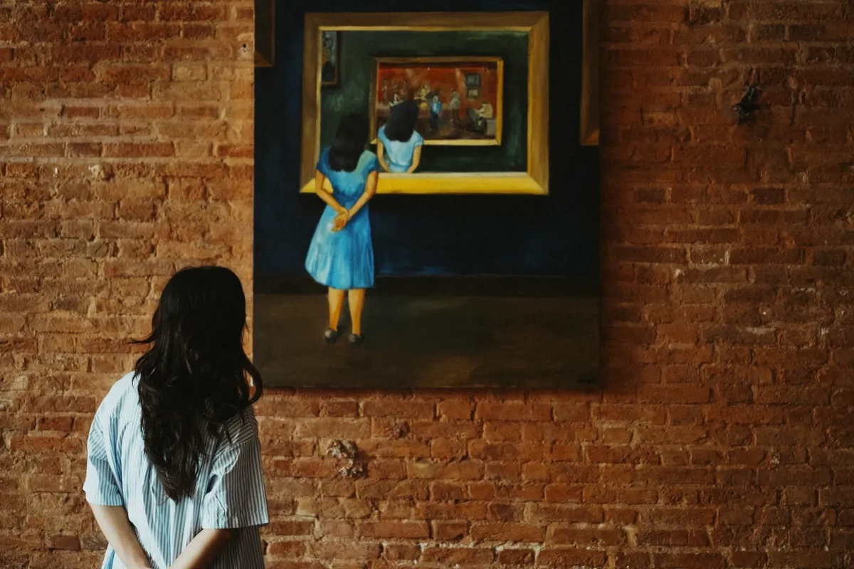 美術館で、風景画を眺めている女性、風味のあるレンガ壁が背景に